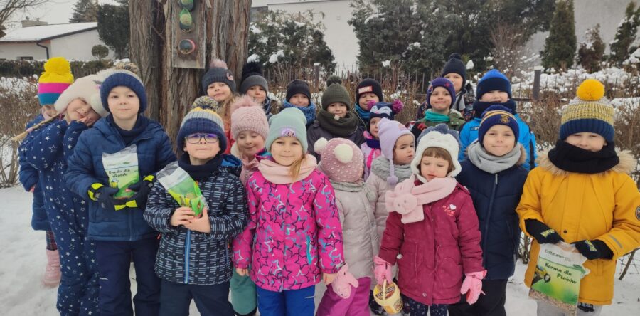 Przedszkolaki dokarmiają ptaki